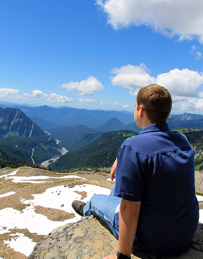 Wesley sitting at Mount Rainier looking into the distance.